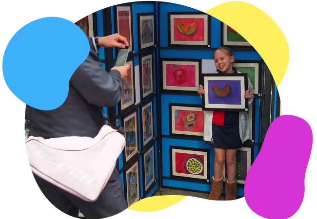 Child posing for photograph with artwork